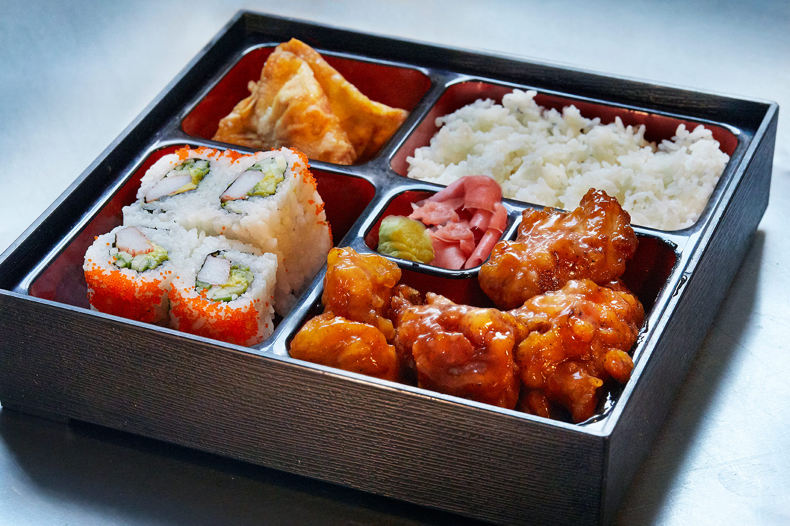 Bento Box. Orange Chicken, California roll, gyoza and rice