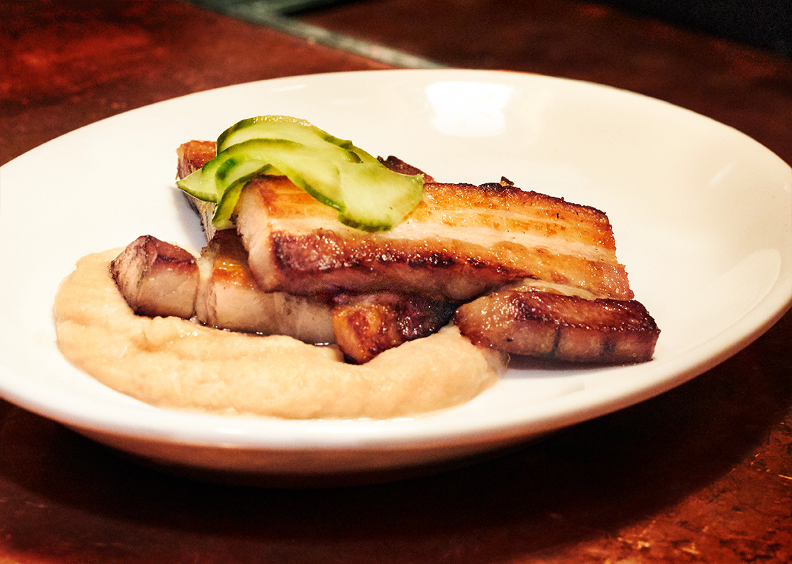 Miso cherry glazed pork belly with smoked white bean puree served with house pickles at The Southern Steak and Oyster Restaurant in Nashville